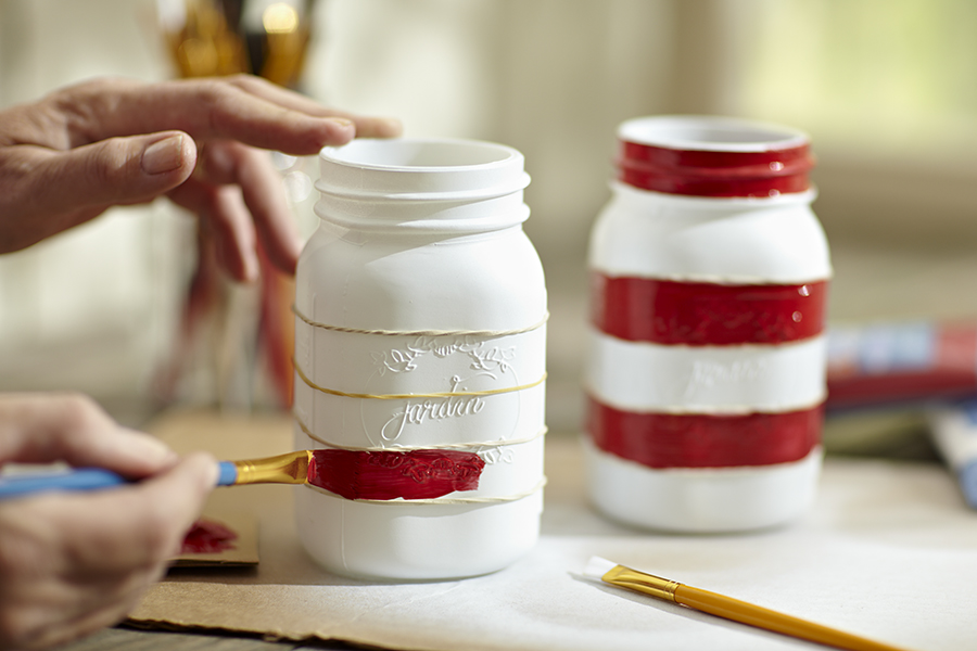 Photo of person painting mason jars