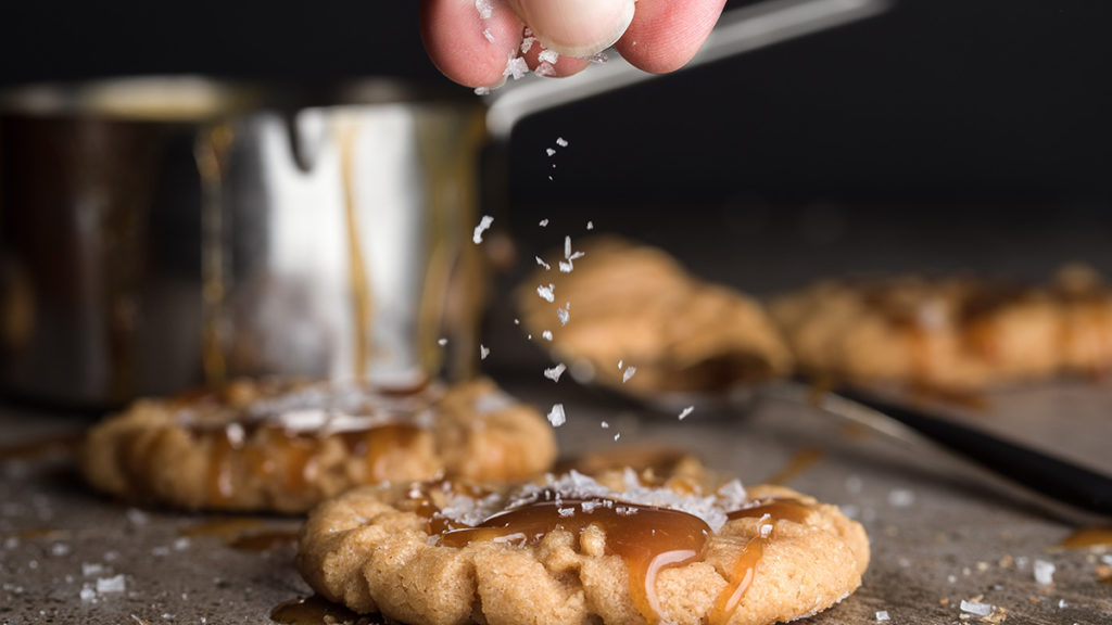 Flavor pairings of sea salt being sprinkled on a cookie