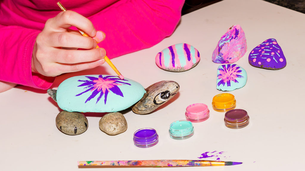 Photo of a kid painting stones