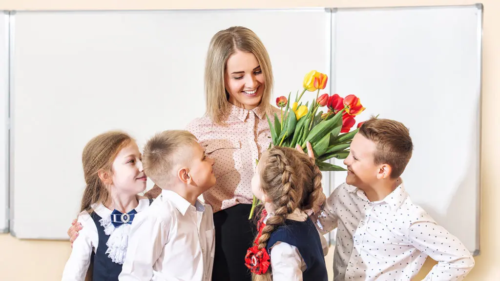 Photo of a teacher getting teacher gifts from her students