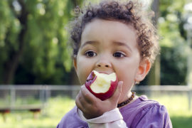 Photo of a kid eating an apple