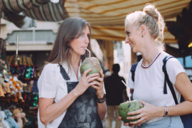 Photo of two women enjoying coconuts