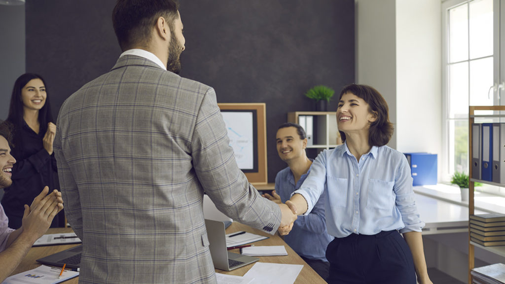 Photo of two colleagues shaking hands in a work meeting