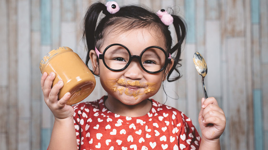 Photo of a girl eating peanut butter