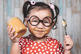Photo of a girl eating peanut butter