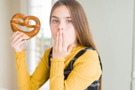 Photo of a girl eating a pretzel
