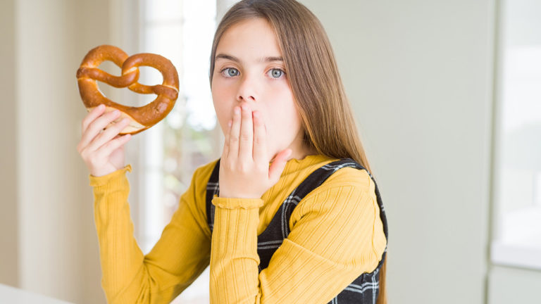 Photo of a girl eating a pretzel