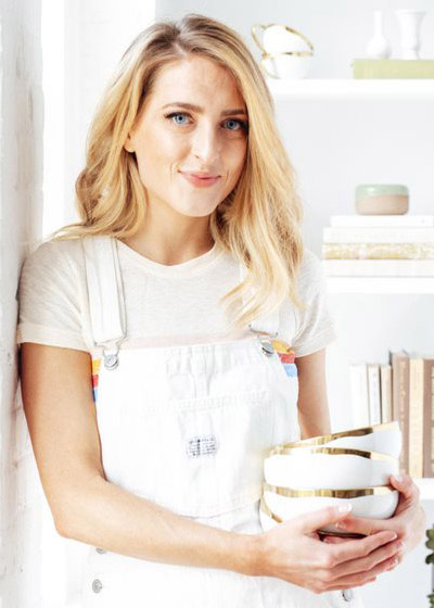 Photo of Sarah Crawford, founder of Broma Bakery, holding a stack of bowls