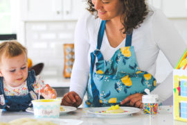 Photo of mother decorating cookies with young daughter
