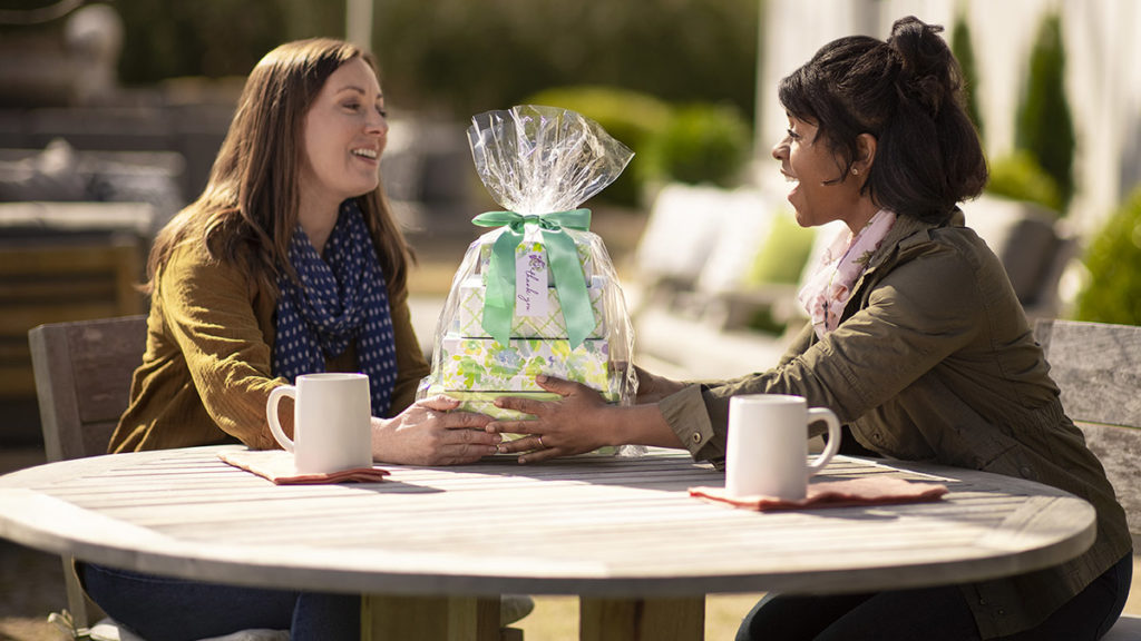 Photo of woman giving friend a gift