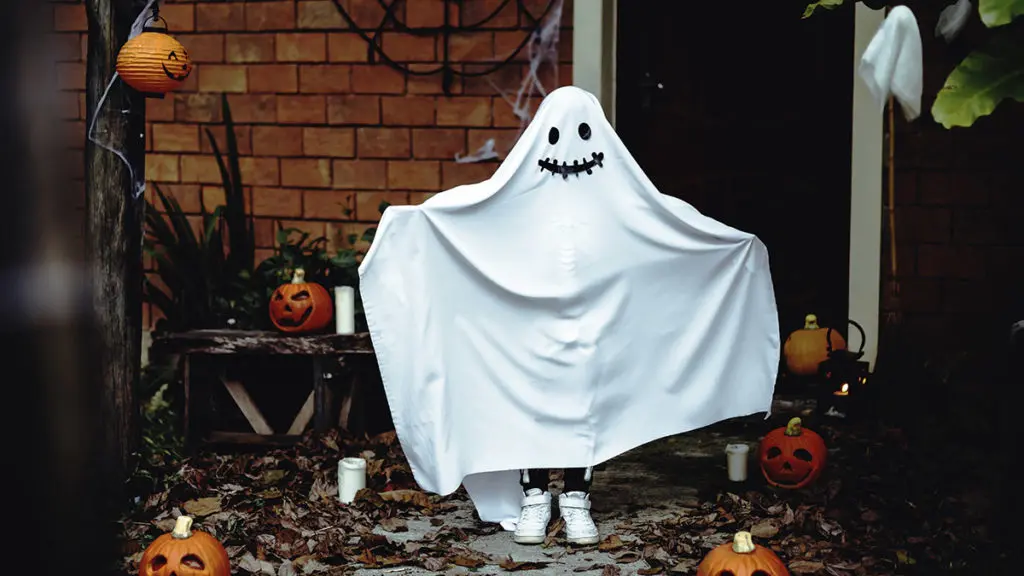 Photo of kid dressed as a ghost at front door