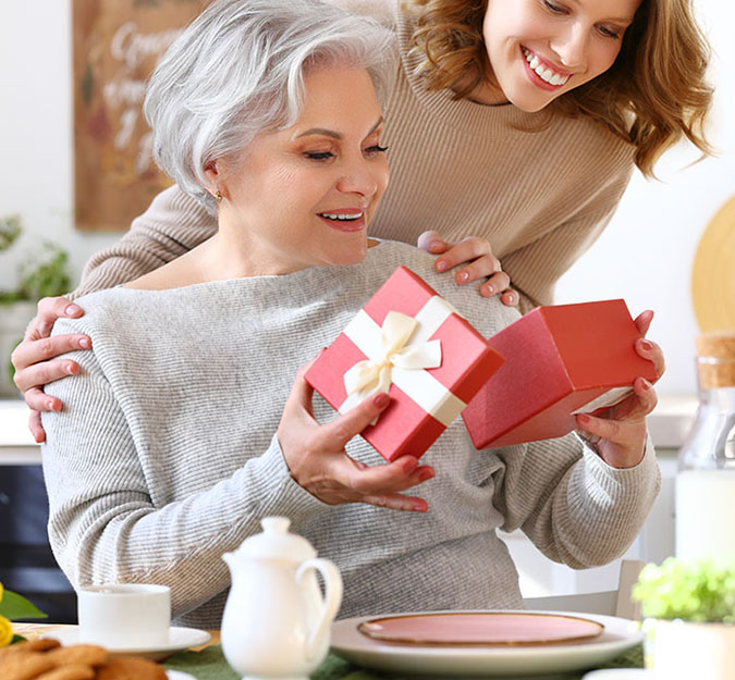 Photo of woman giving another woman a gift