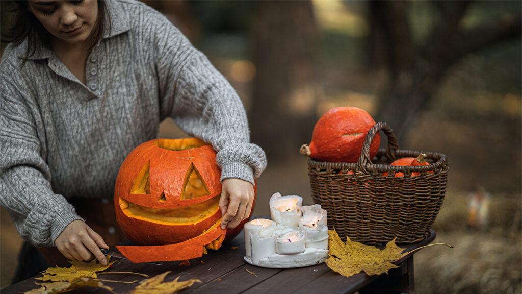 history of Halloween. Woman carving a pumpkin.