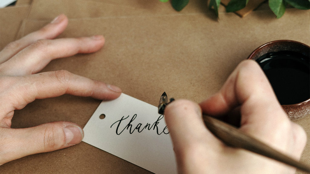 Photo of someone writing a thank-you note