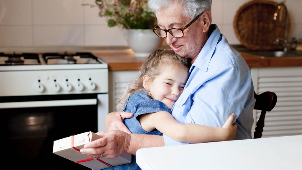 world kindness day with child giving a gift to her grandmother