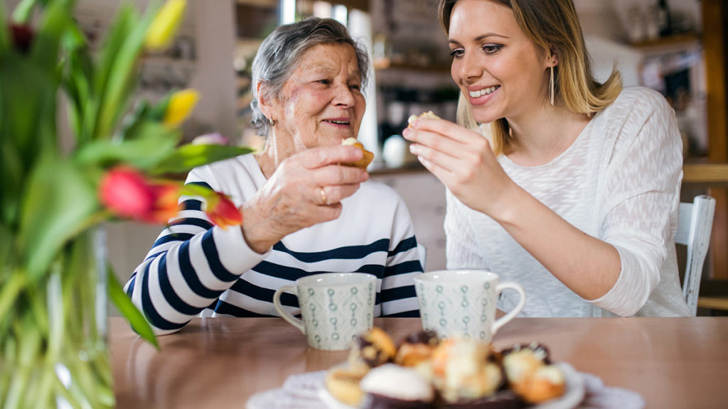 Photo of an elderly woman eating a cupcake