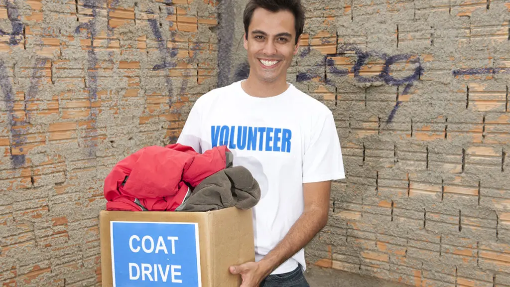 Photo of a man collecting coats for a coat drive