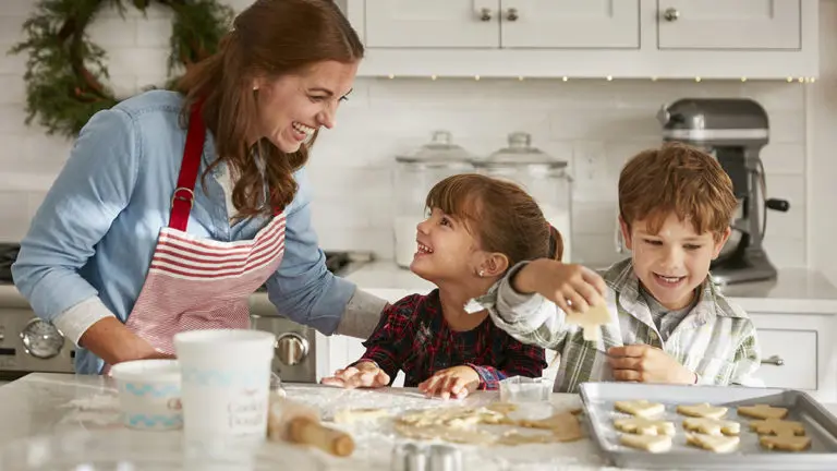 Photo of mom and kids decorating christmas cookies
