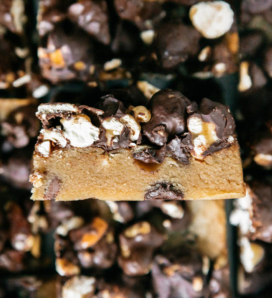 Cookie types with a pile of Moose Munch blondies on a tray.