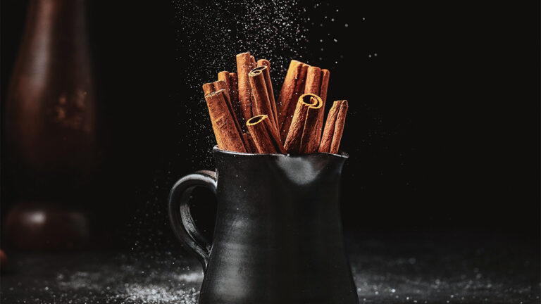 facts about cinnamon. Mug filled with cinnamon sticks.