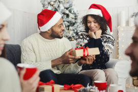 Photo of man surprising woman with Christmas gift