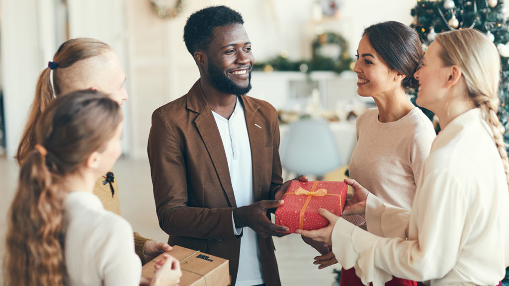 Photo of man giving gift to holiday hostess