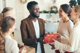 Photo of man giving gift to holiday hostess