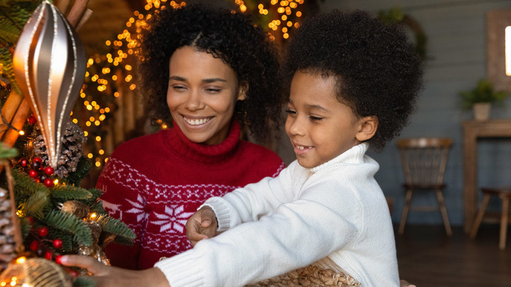 Photo of mother and son hanging christmas decorations