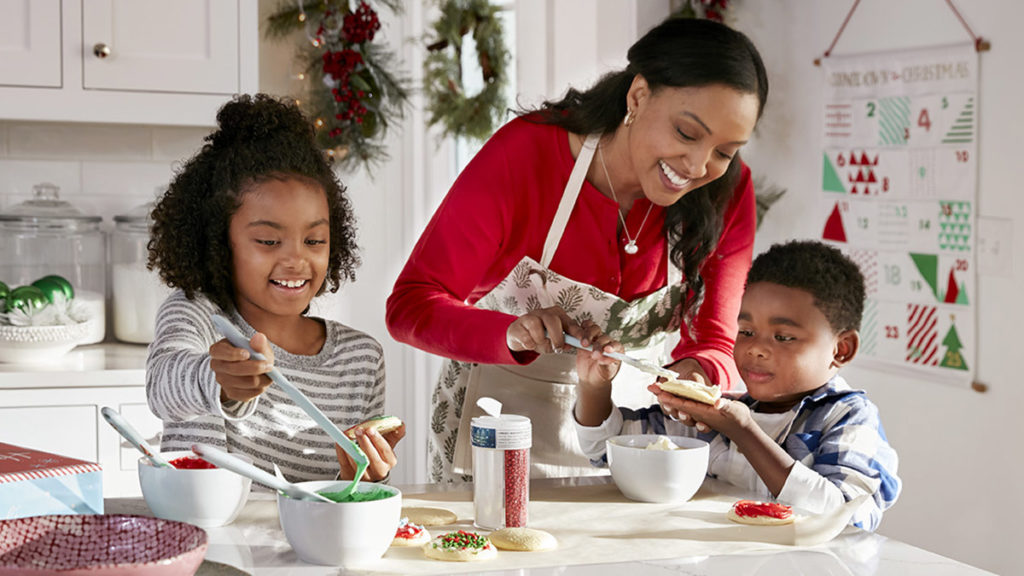 Christmas activities for families with mom and kids decorating christmas cookies