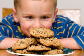Photo of boy gazing at cookies on National Cookie Day