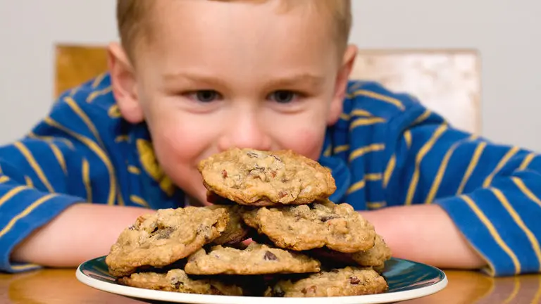Photo of boy gazing at cookies on National Cookie Day