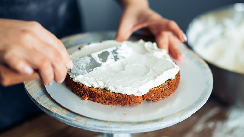 Photo of woman frosting a cake