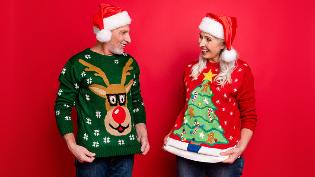 ugly sweater party with people posing in front of red background