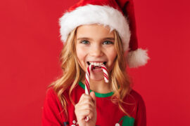 history of peppermint girl in santa hat eating candy cane