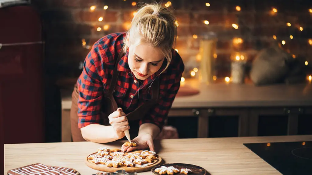 photo of woman decorating cookies for holiday cookie exchange