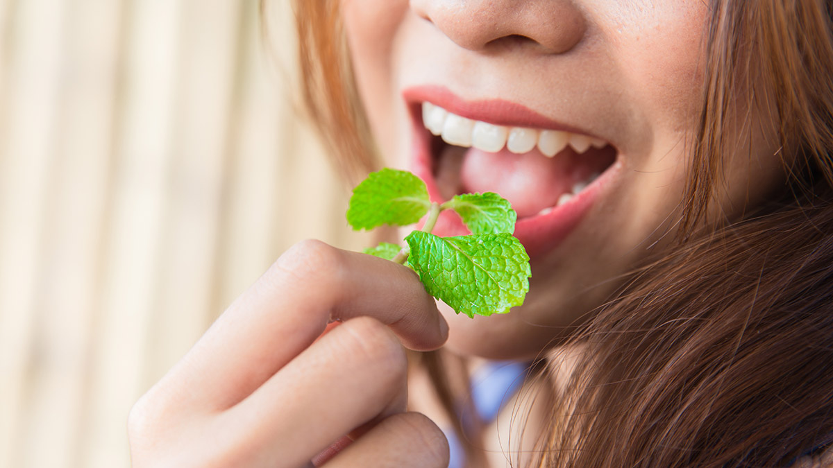Photo of woman eating mint leaves