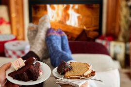 winter gifts couple's feet warming by a fireplace.