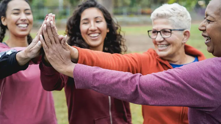 International Women's Day: women high-fiving one another