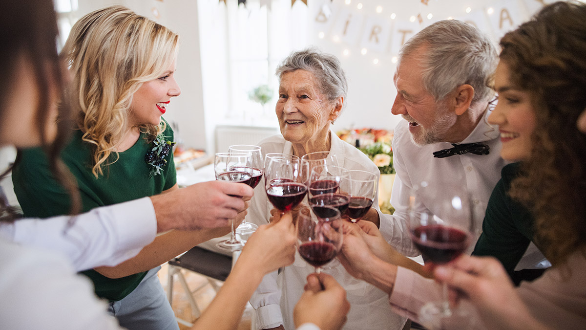 birthday party ideas for seniors with attendees toasting the honoree