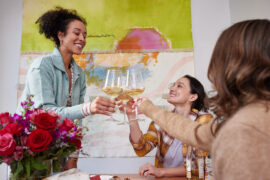 galentines day party with women toasting wine glasses.