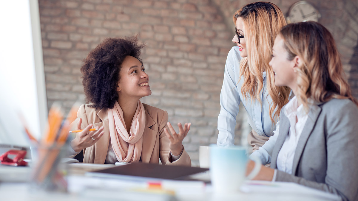 Women in an office talking on International Women's Day