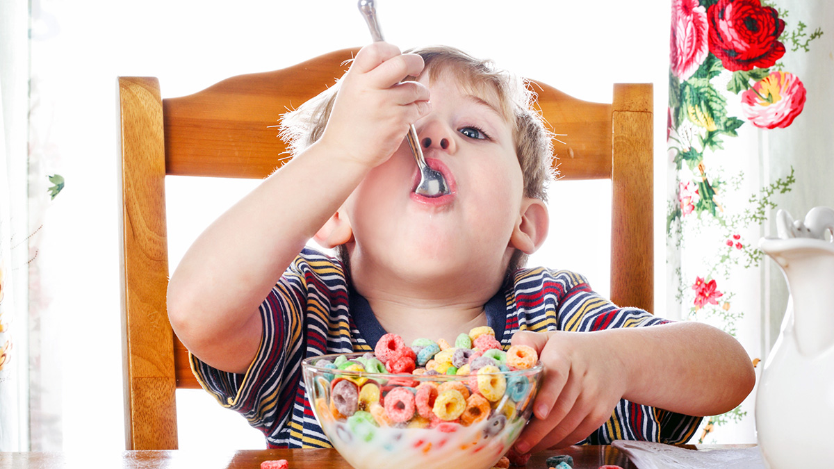 food nostalgia: young boy eating fruity cereal