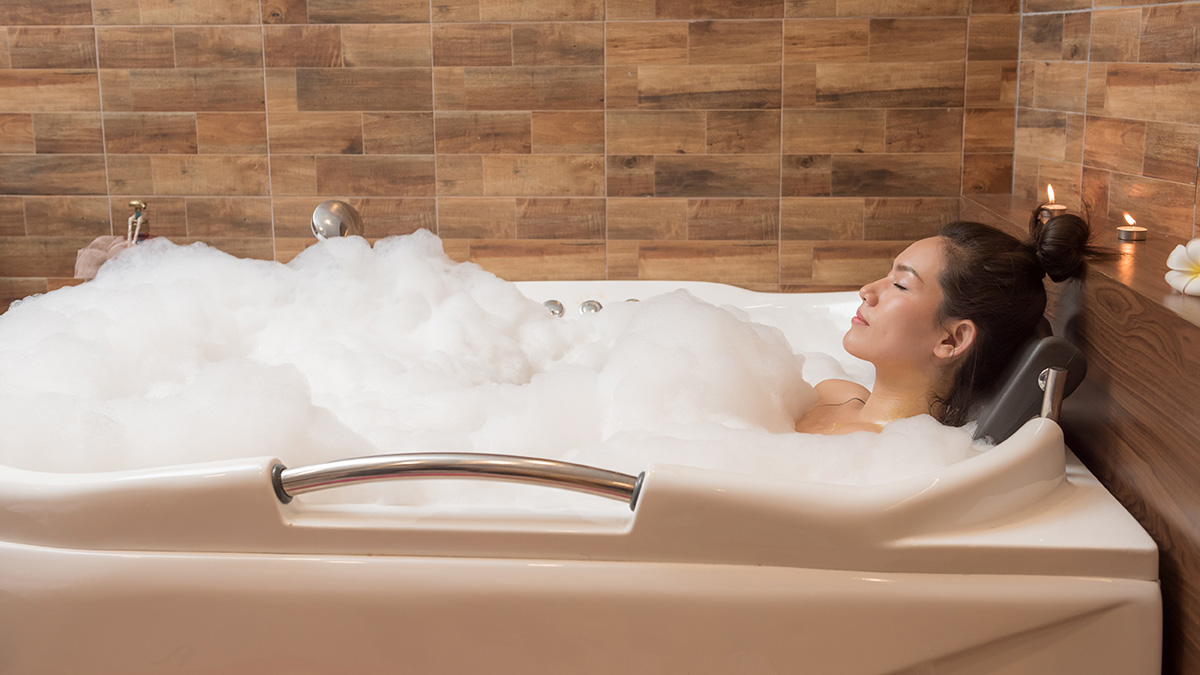 a photo of new parents with mom taking a relaxing bath