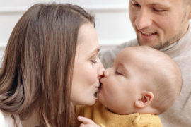 A photo of advice for new parents: new mom kissing baby