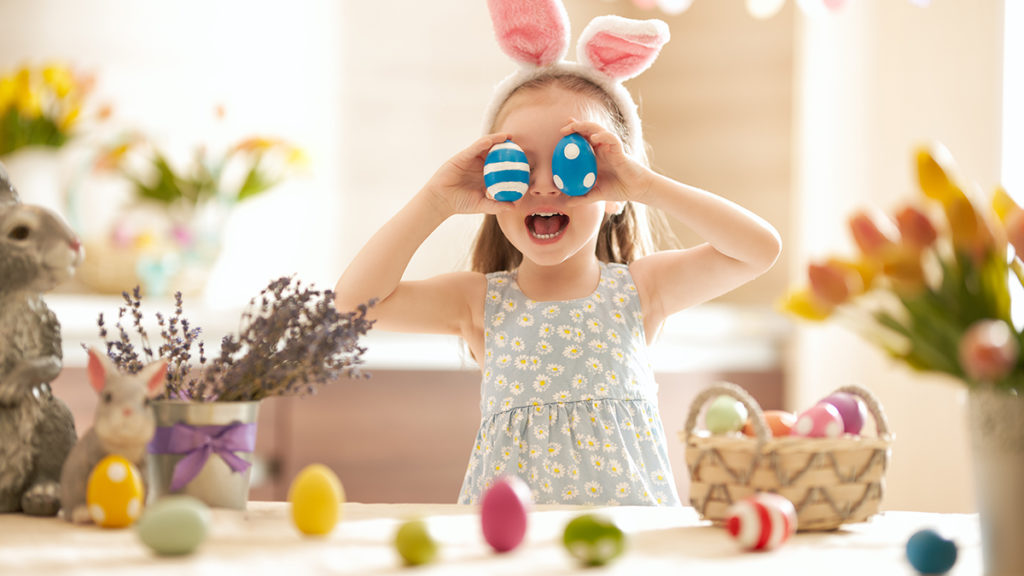 a photo of easter egg decorating ideas: girl playing with easter eggs