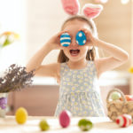 a photo of easter egg decorating ideas: girl playing with easter eggs