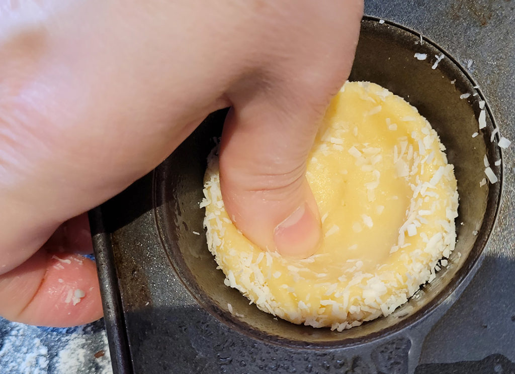 a photo of Easter cookie decorating: pressing dough into nest with finger