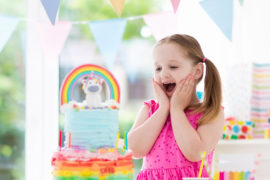 a photo of a unicorn birthday party: young girl celebrating at unicorn birthday party