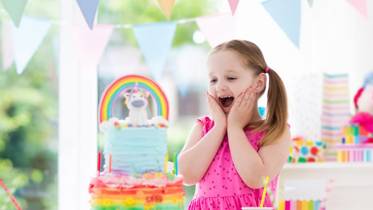 a photo of a unicorn birthday party: young girl celebrating at unicorn birthday party