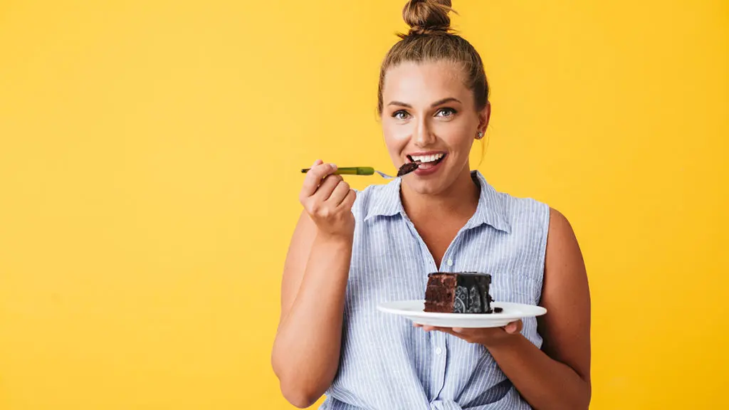 a photo of a woman eating devil's food cake